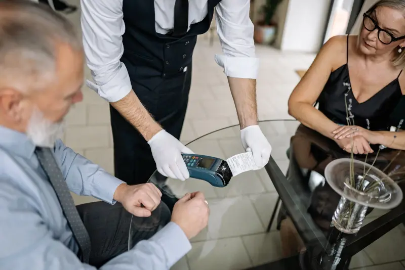 Server holding a card terminal and a printed receipt